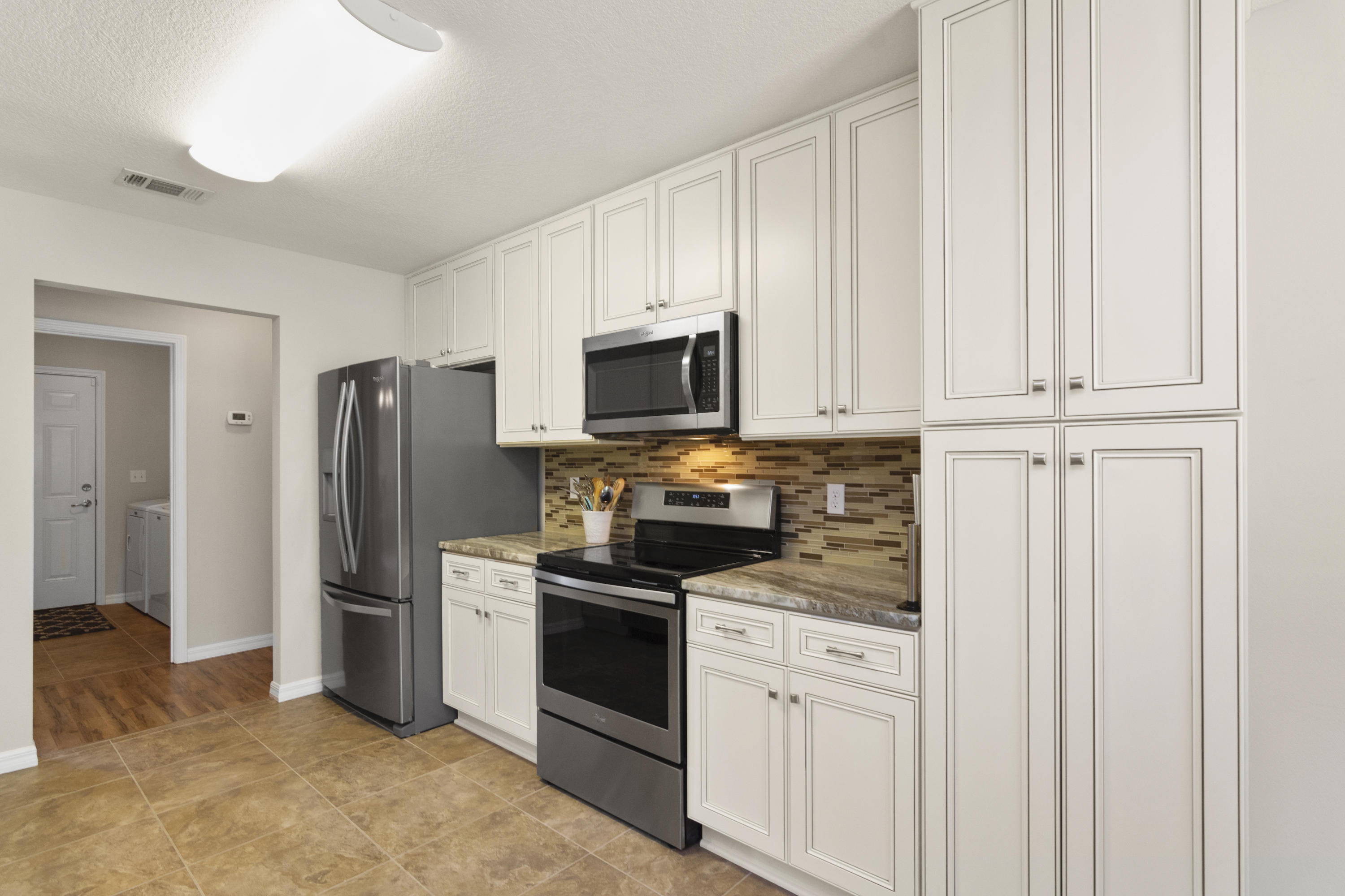 6336 Possum Ridge Road Crestview, FL 32539 - Photo 15 of 40 a kitchen with stainless steel appliances granite countertop white cabinets and refrigerator
