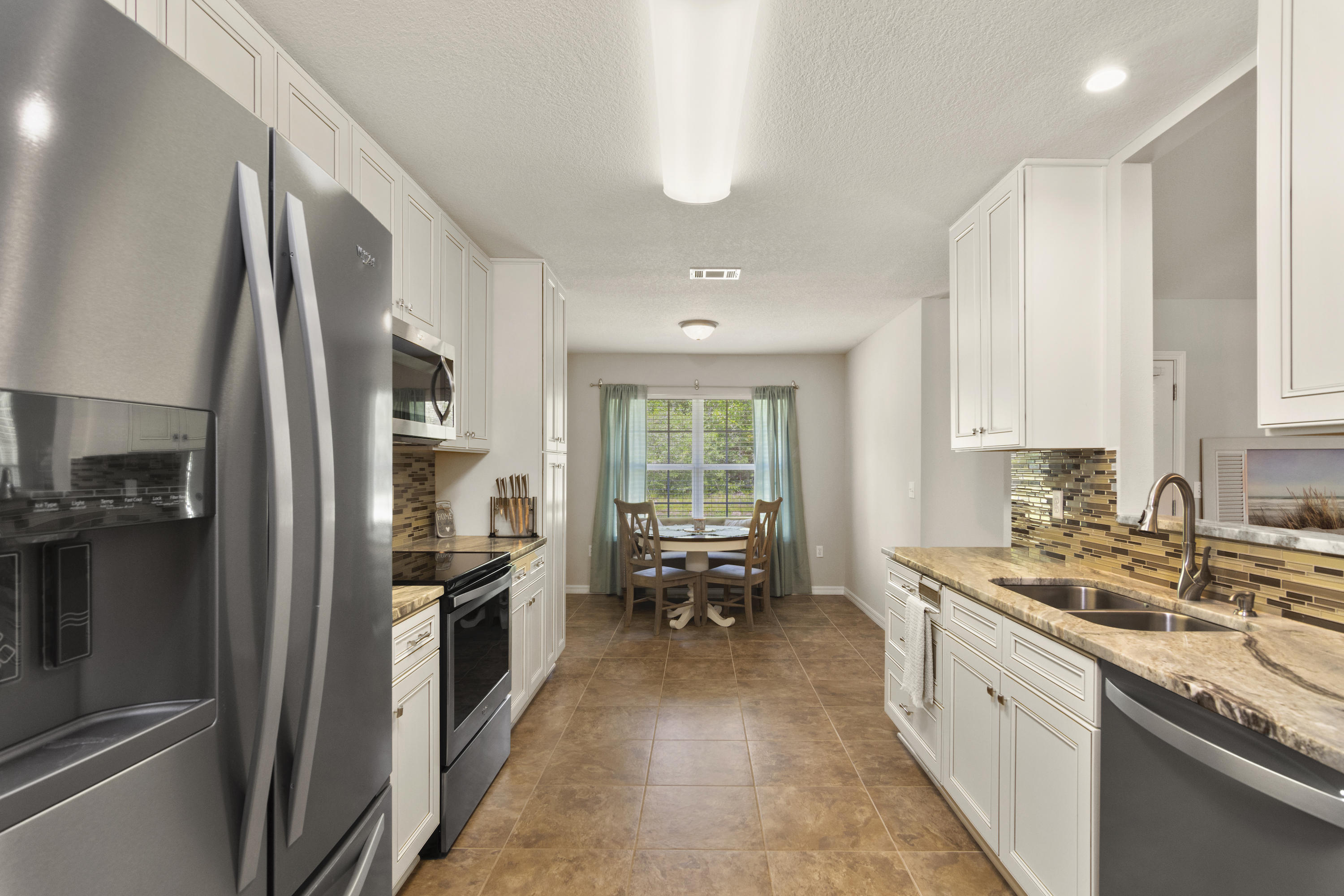 6336 Possum Ridge Road Crestview, FL 32539 - Photo 17 of 40 a large kitchen with a large window and stainless steel appliances