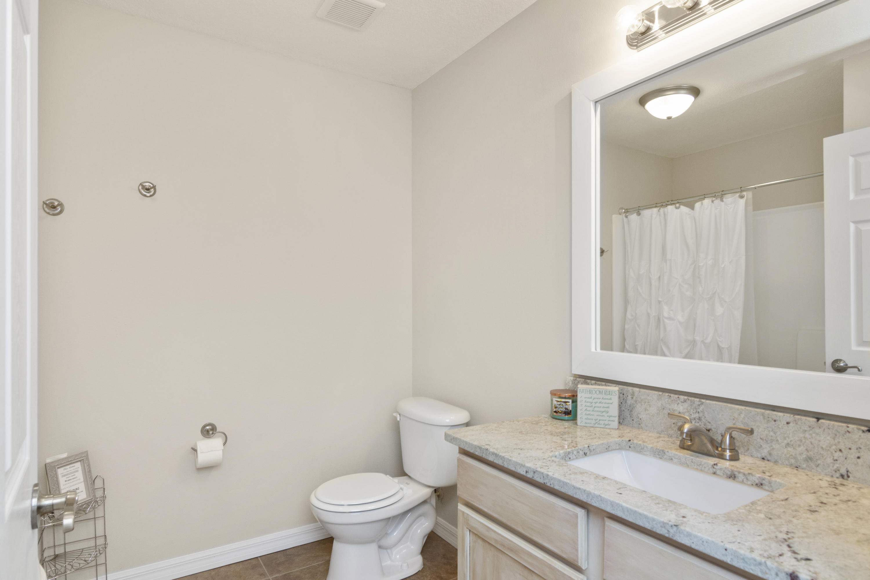 6336 Possum Ridge Road Crestview, FL 32539 - Photo 26 of 40 a bathroom with a granite countertop sink a toilet and a mirror