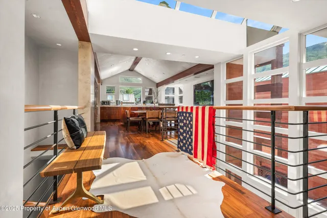 a dining hall with stainless steel appliances granite countertop a stove a sink dishwasher and a dining table with wooden floor