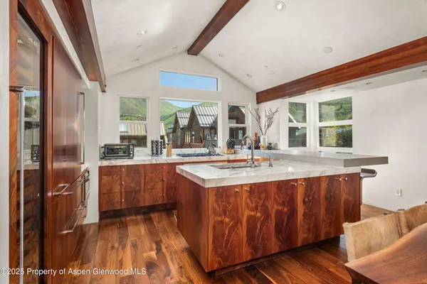 a dining hall with stainless steel appliances granite countertop a stove and a sink