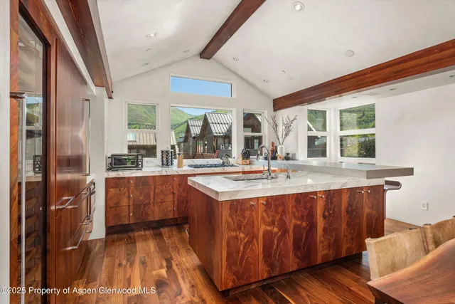 a dining hall with stainless steel appliances granite countertop a stove and a sink