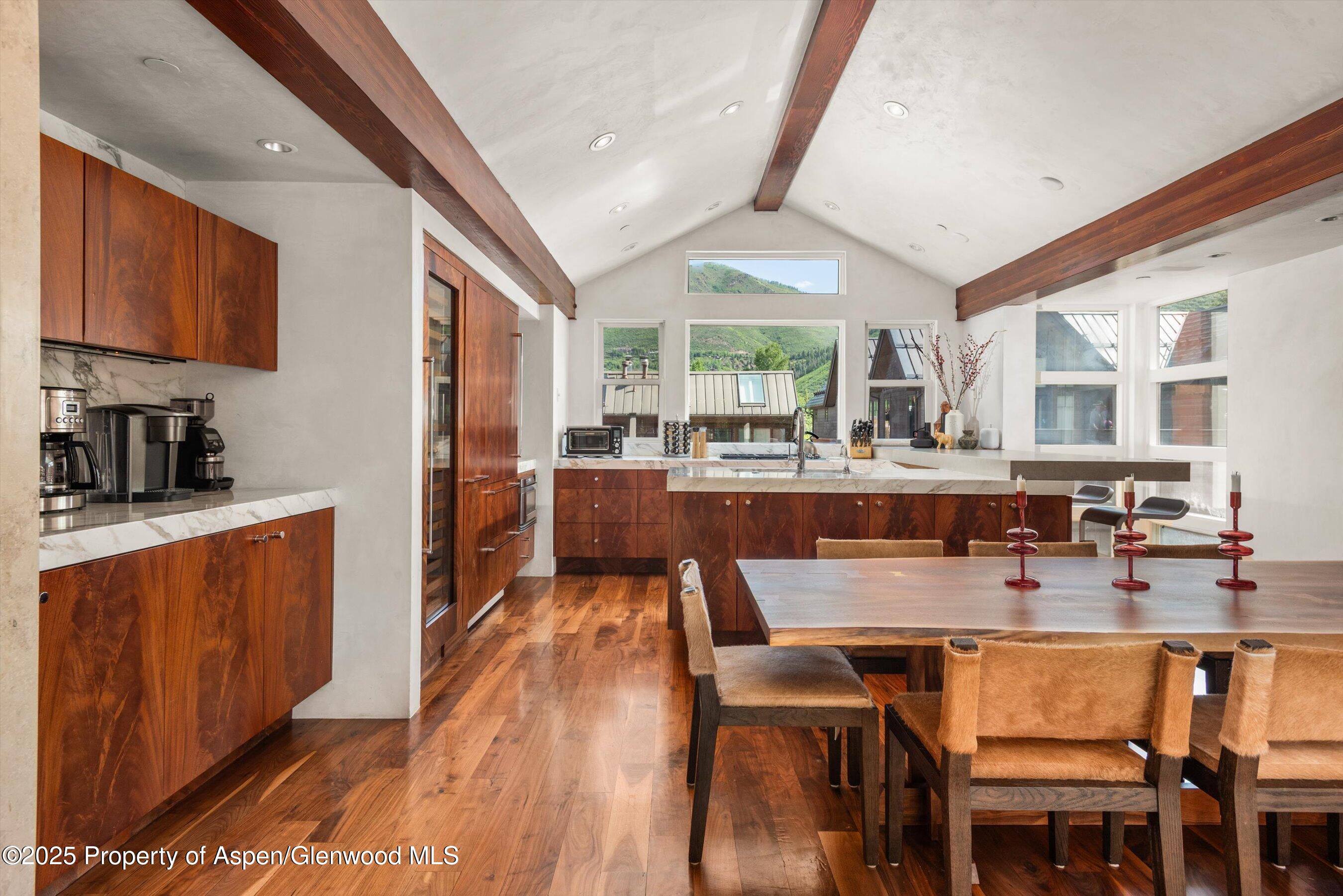 706 East Hyman Avenue, Unit 706 Aspen, CO 81611 - Photo 16 of 46 a dining hall with stainless steel appliances granite countertop a stove a sink dishwasher and a dining table with wooden floor