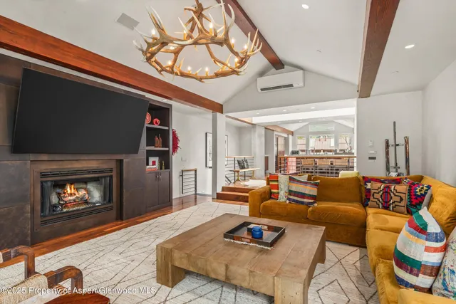 a living room with fireplace furniture and a large window