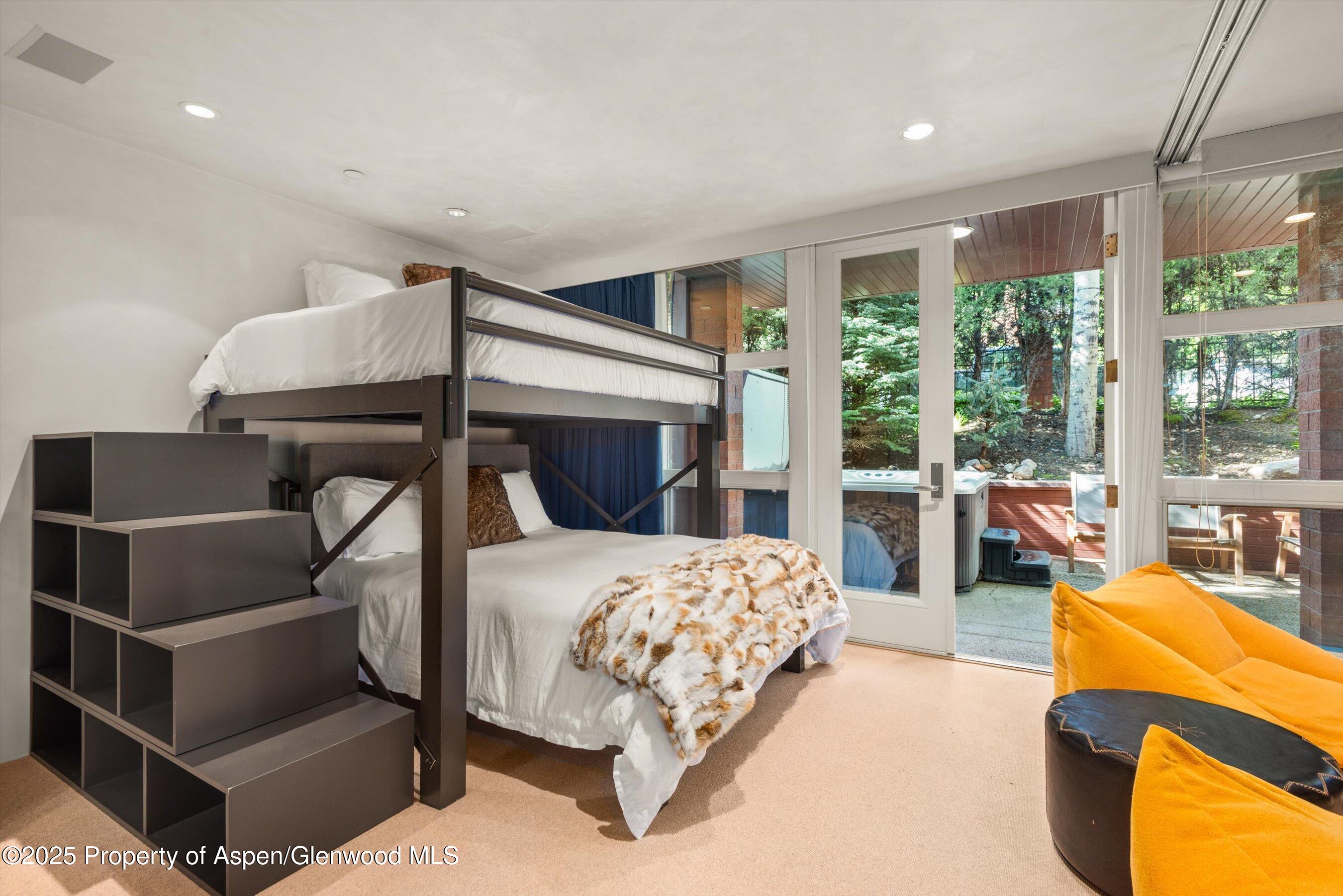 706 East Hyman Avenue, Unit 706 Aspen, CO 81611 - Photo 32 of 46 a bedroom with a bed and glass window