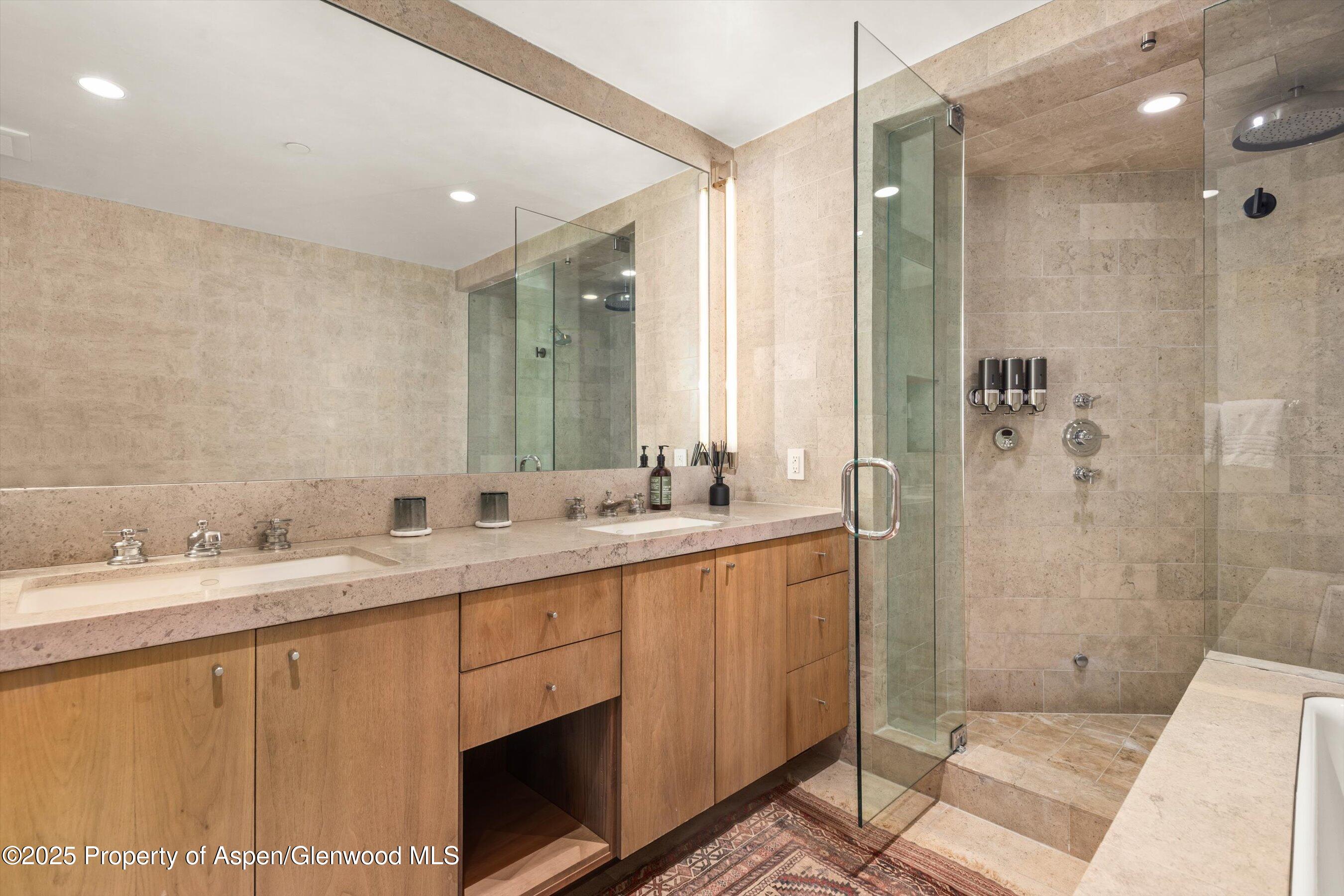 706 East Hyman Avenue, Unit 706 Aspen, CO 81611 - Photo 34 of 46 a bathroom with a double vanity sink mirror and shower