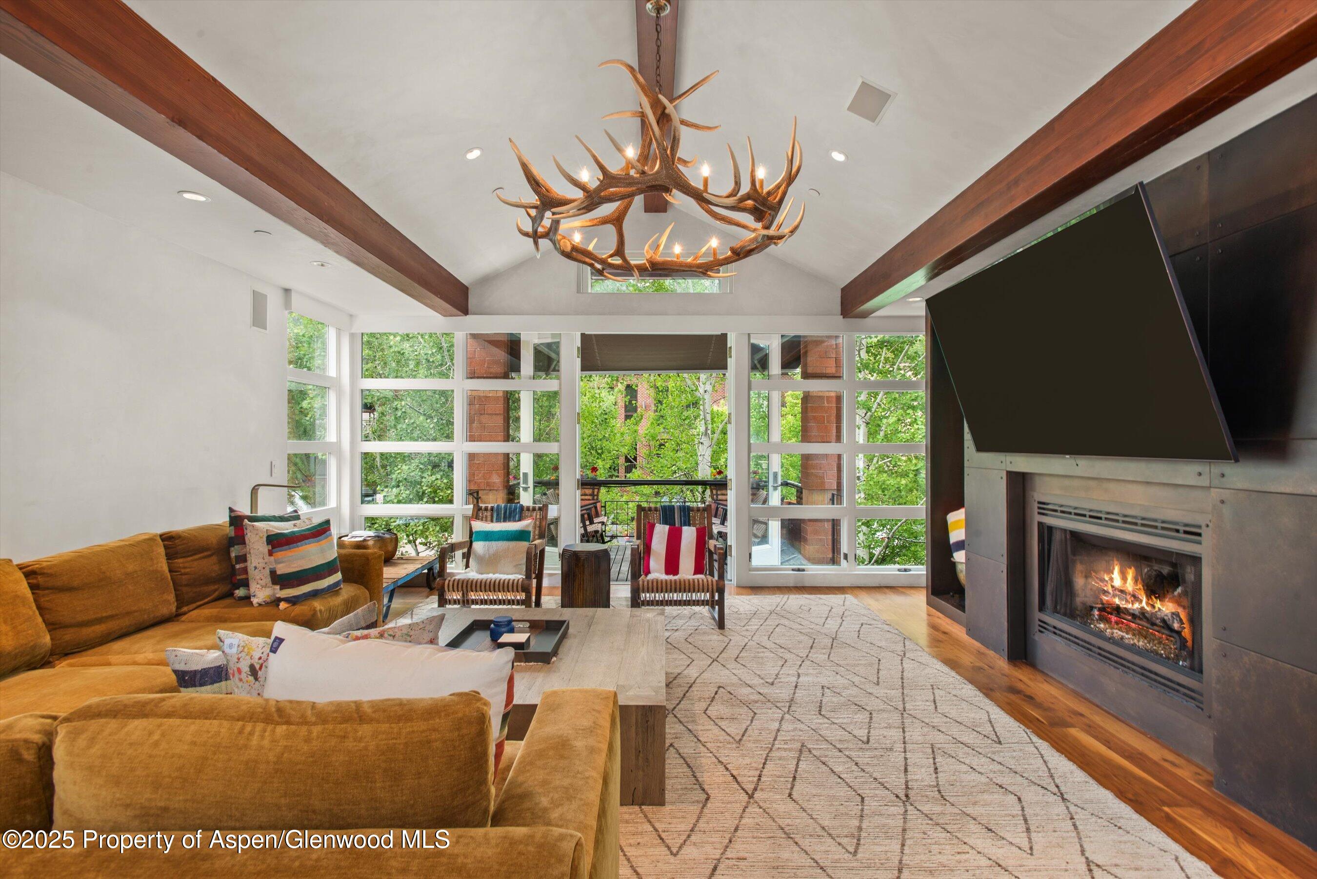 706 East Hyman Avenue, Unit 706 Aspen, CO 81611 - Photo 4 of 46 a living room with fireplace furniture and a large window
