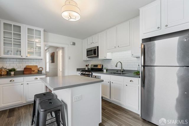 a kitchen with cabinets a refrigerator and a stove top oven