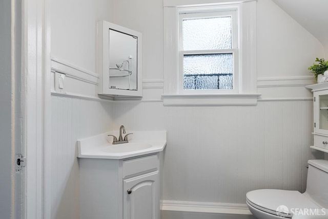 a bathroom with a sink a toilet and a window