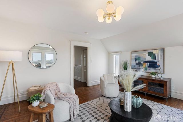a living room with furniture a mirror and a table