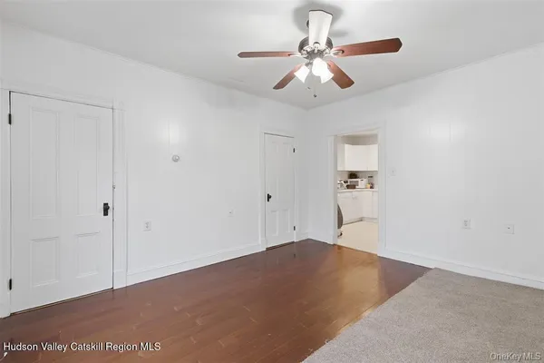 an empty room with a ceiling fan and a window