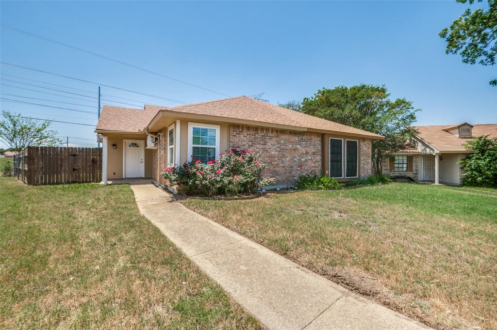 7305 Pineberry Road Dallas, TX 75249 - Photo 2 of 25 a front view of a house with a yard and a garage