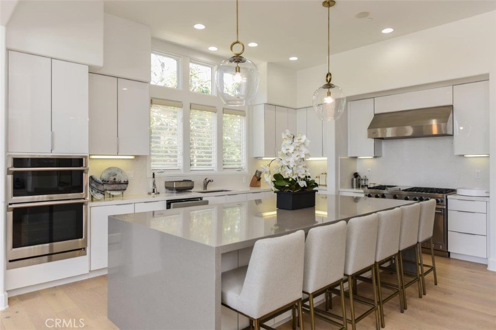7 Via Brezza Newport Coast, CA 92657 - Photo 24 of 75 a kitchen with stainless steel appliances granite countertop a stove a sink a microwave a dining table and chairs