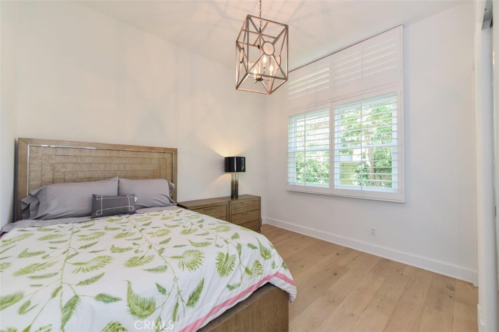 7 Via Brezza Newport Coast, CA 92657 - Photo 36 of 75 a bedroom with a bed and a chandelier