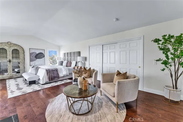 a spacious bedroom with a bed and wooden floor