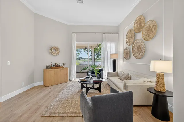 a living room with furniture kitchen view and a chandelier