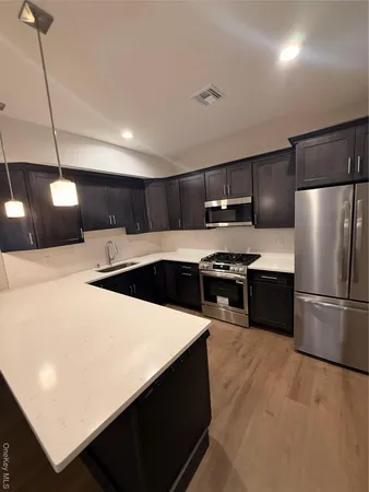 a kitchen with stainless steel appliances a refrigerator and a stove top oven