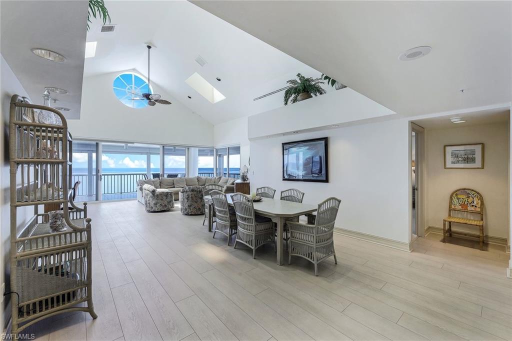 20 Seagate Drive, Unit 1102 Naples, FL 34103 - Photo 13 of 40 a living room with patio furniture and a wooden floor