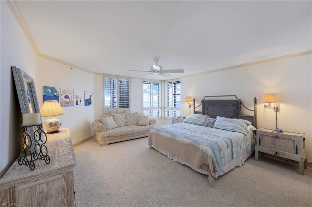 20 Seagate Drive, Unit 1102 Naples, FL 34103 - Photo 21 of 40 a spacious bedroom with a bed and a couch