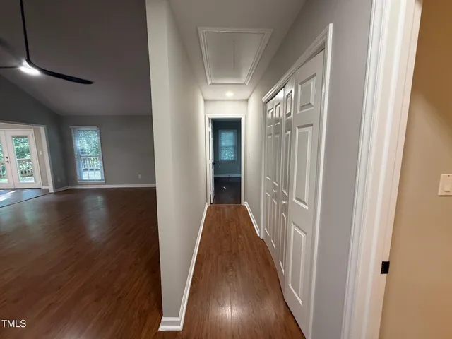 a view of a hallway with wooden floor and stairs