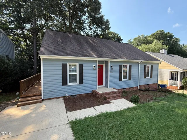 a front view of a house with a yard and trees