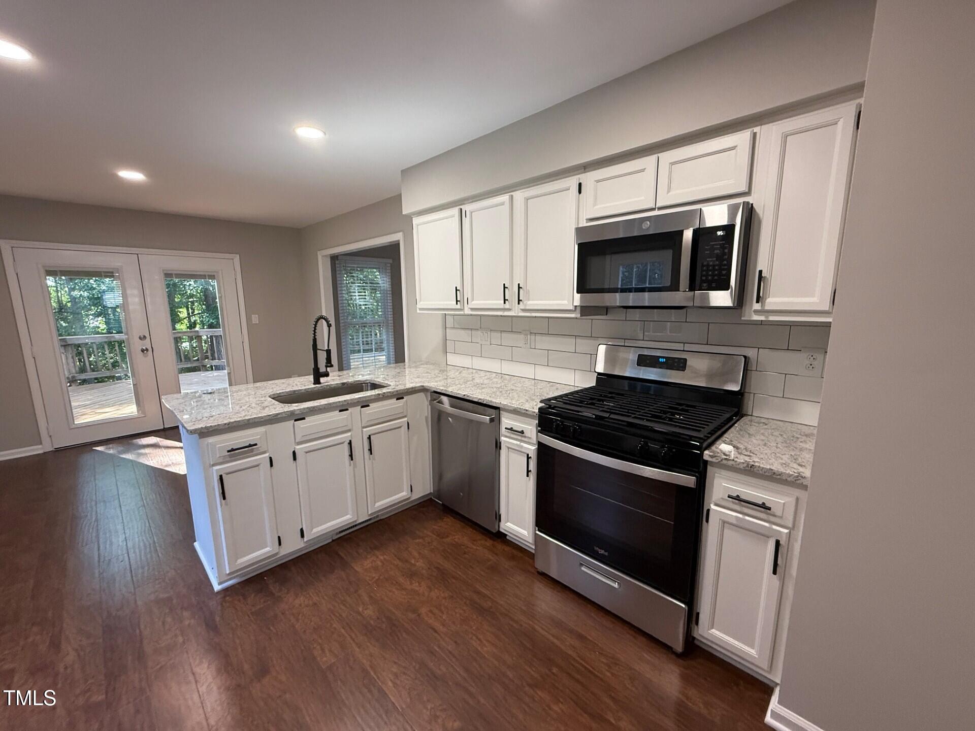 8316 Bellingham Circle Raleigh, NC 27615 - Photo 9 of 22 a kitchen with stainless steel appliances granite countertop a stove a sink and a microwave