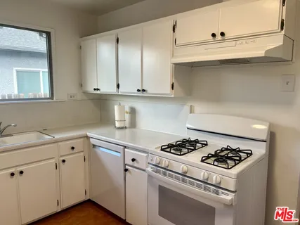 a kitchen with cabinets and white appliances