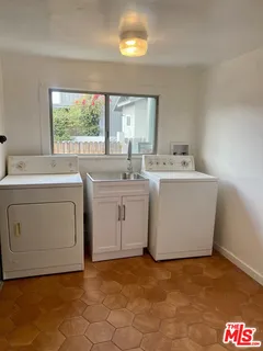 a utility room with cabinets washer and dryer