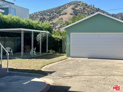 a view of a patio with table and chairs potted plants and floor to ceiling window