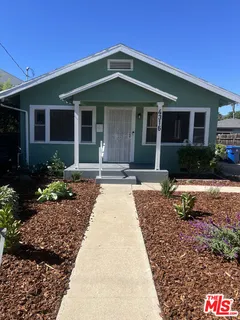 a front view of a house with a yard and outdoor seating