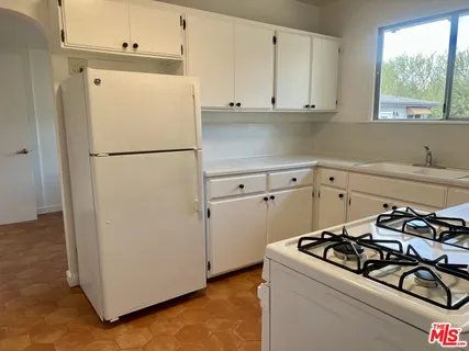 a white refrigerator freezer and a stove sitting inside of a kitchen