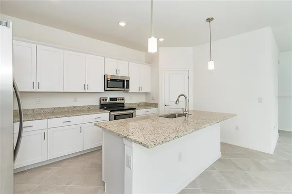 a kitchen with a sink a microwave and cabinets