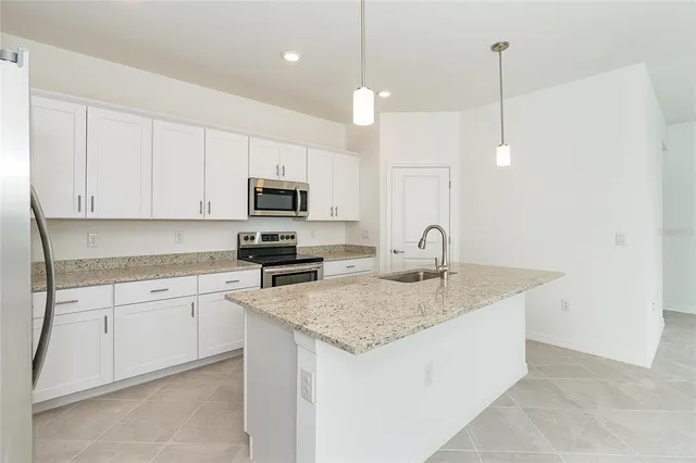 a kitchen with a sink a microwave and cabinets