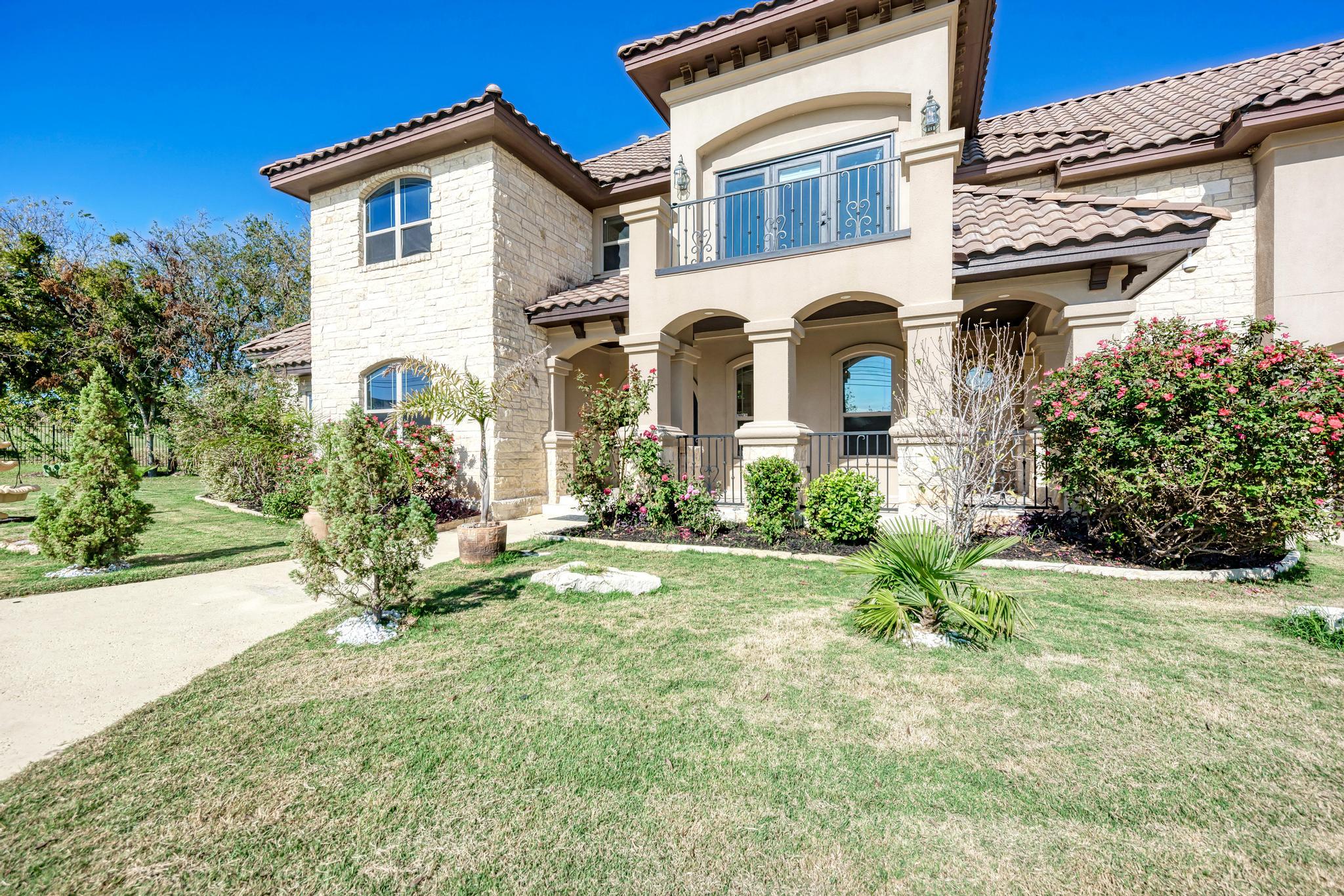104 Spring Valley Street Hutto, TX 78634 - Photo 6 of 40 Mediterranean / spanish home with a front lawn, stucco siding, a tile roof, a balcony, and a porch