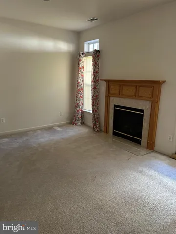 a view of empty room with a fireplace