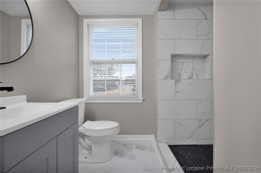 382 Saddle Ridge Road Fayetteville, NC 28311 - Photo 20 of 22 a bathroom with a granite countertop sink a toilet and a mirror