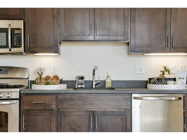 a kitchen with stainless steel appliances granite countertop a sink a stove and cabinets