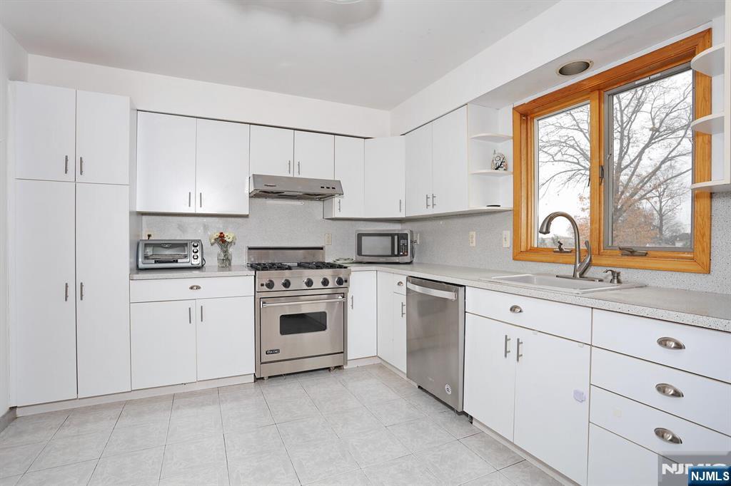 140 Prospect Street Hasbrouck Heights, NJ 07604 - Photo 11 of 28 a kitchen with cabinets appliances a sink and a window