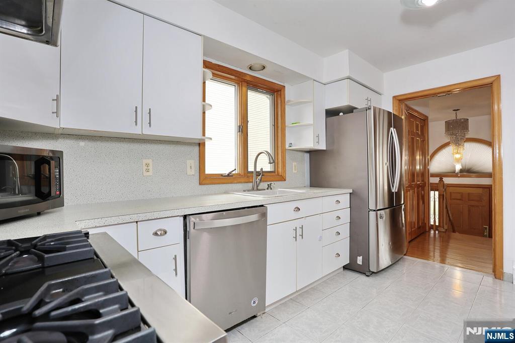 140 Prospect Street Hasbrouck Heights, NJ 07604 - Photo 13 of 28 a kitchen with white cabinets and a stove