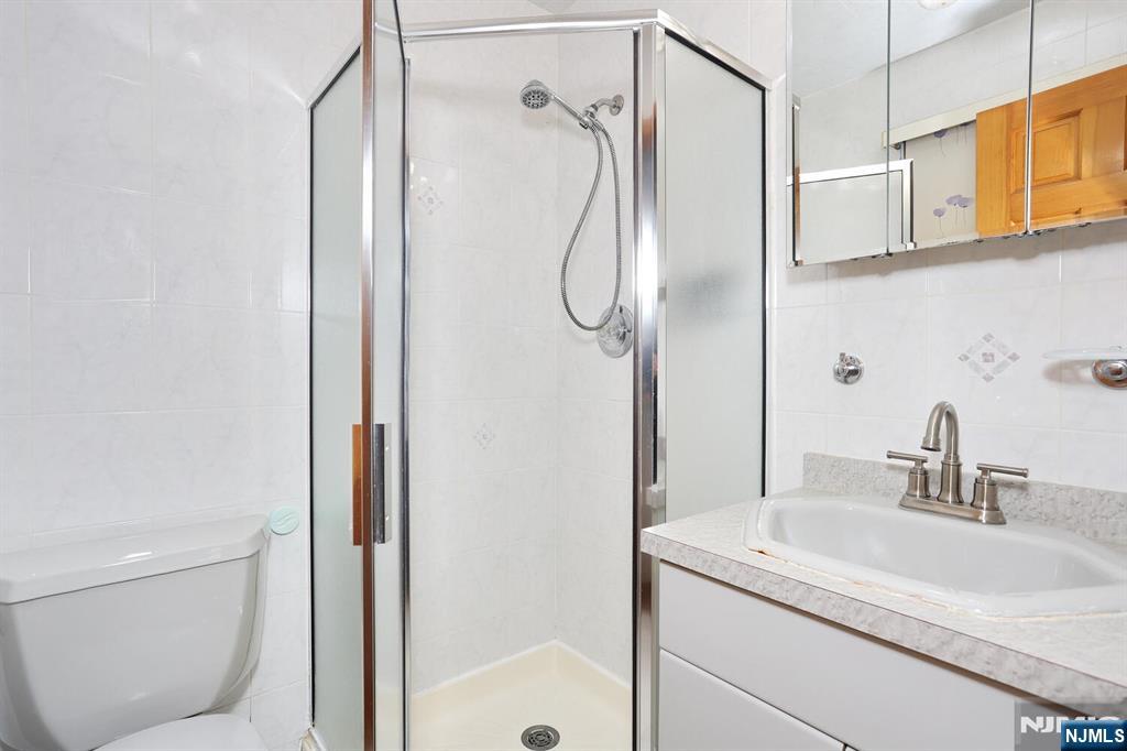 140 Prospect Street Hasbrouck Heights, NJ 07604 - Photo 17 of 28 a bathroom with a granite countertop sink a toilet and shower