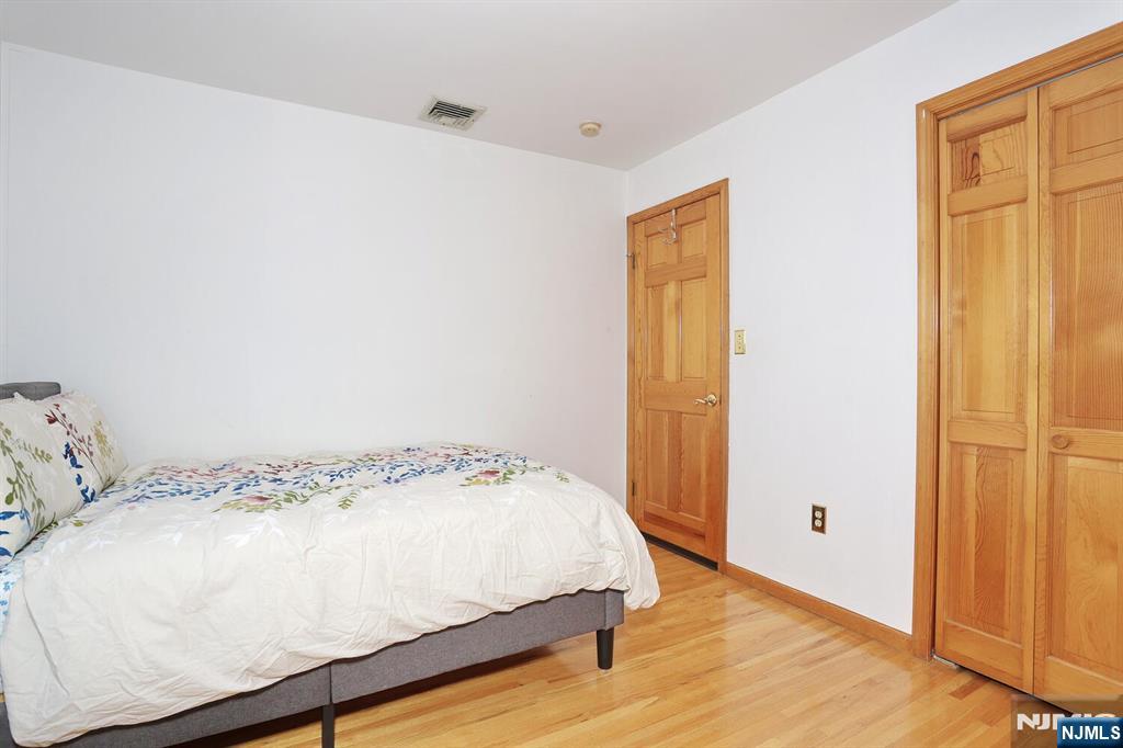 140 Prospect Street Hasbrouck Heights, NJ 07604 - Photo 19 of 28 a bedroom with a bed and wooden floor