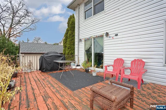 a view of a patio with wooden table and chairs