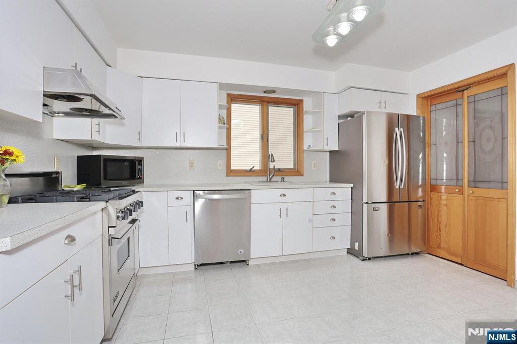 140 Prospect Street Hasbrouck Heights, NJ 07604 - Photo 10 of 28 a kitchen with white cabinets and white appliances