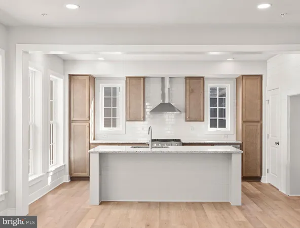 a close view of kitchen island with stainless steel appliances granite countertop a stove and a large window