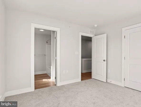 an empty room with closet and a bathroom