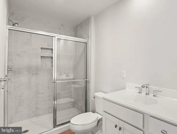 a bathroom with a shower sink vanity mirror and toilet