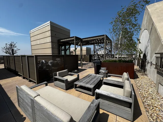 a view of a patio with couches and chairs under an umbrella