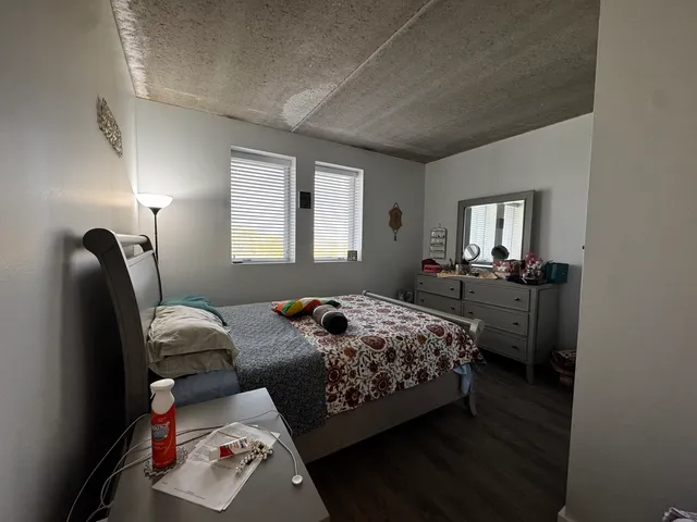 a bedroom with a bed and wooden floor