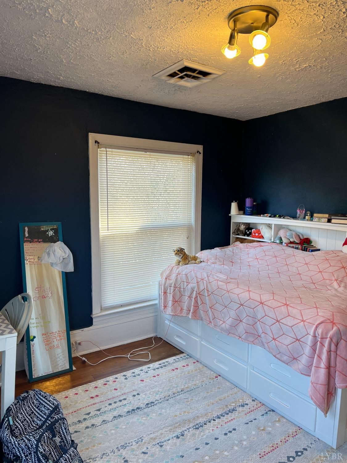 9710 Forest Road Goode, VA 24556 - Photo 34 of 49 a bedroom with a bed and wooden floor