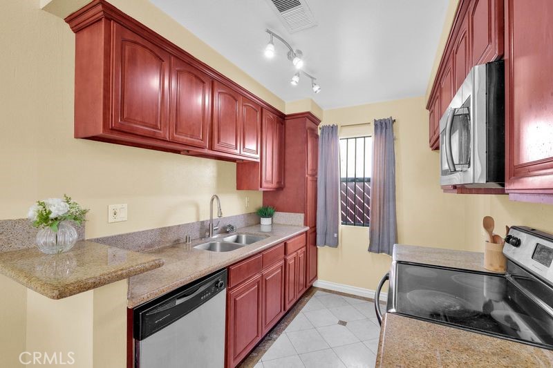 1781 Neil Armstrong Street, Unit 112 Montebello, CA 90640 - Photo 6 of 19 a kitchen with stainless steel appliances granite countertop a sink stove and cabinets